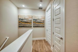 Upstairs hallway with wood panel floors and decorative wall art in an Eagle Trace resort residence.