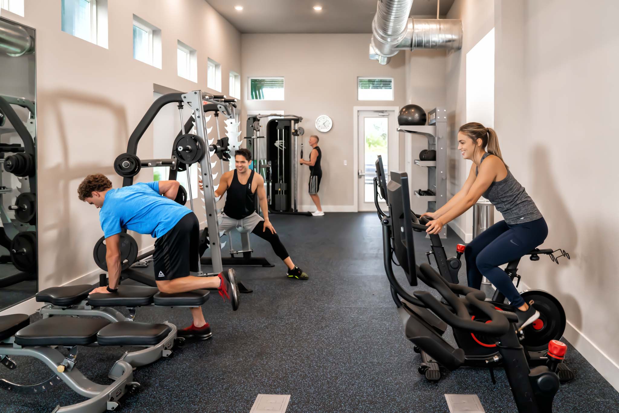 People working out on exercise equipment and bikes in the Eagle Trace clubhouse fitness center.