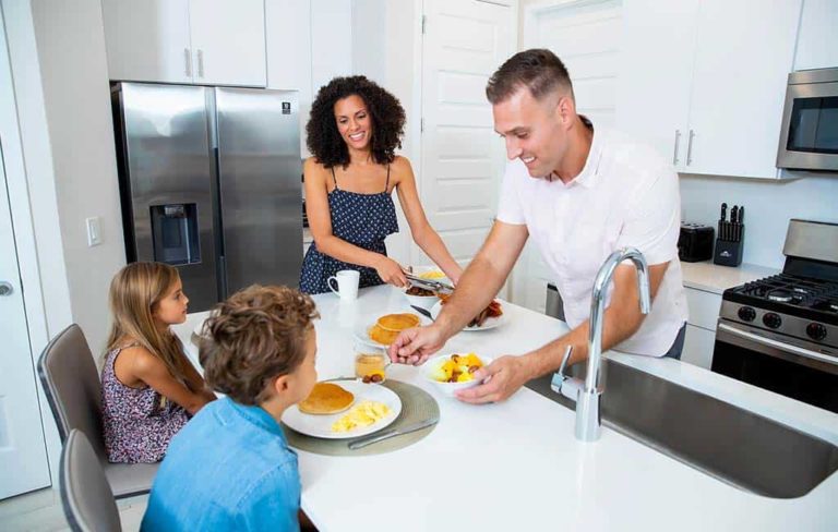 Parents serving kids breakfast on a kitchen island