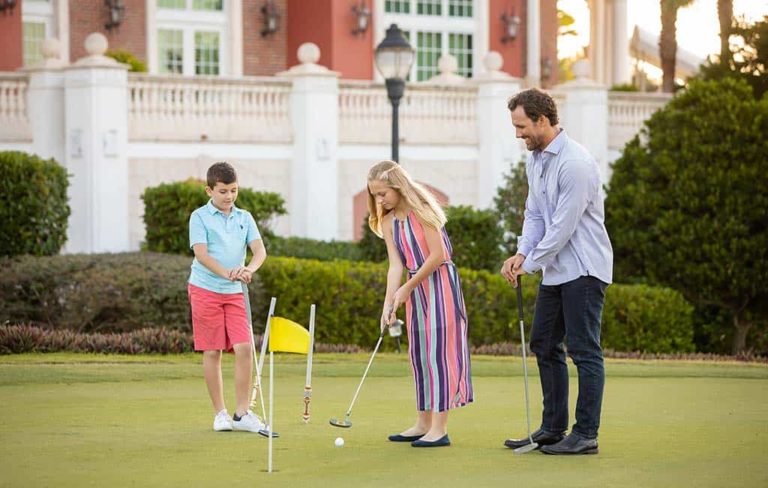 Kids and father playing a round of golf